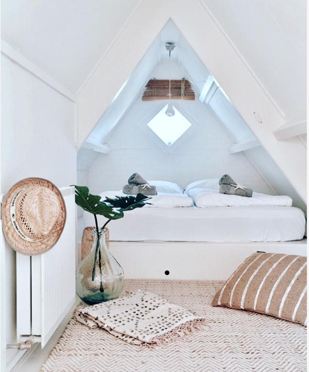 ein Schlafzimmer mit einem Bett und einer Vase auf dem Boden in der Unterkunft ELSK Cottage in Zandvoort
