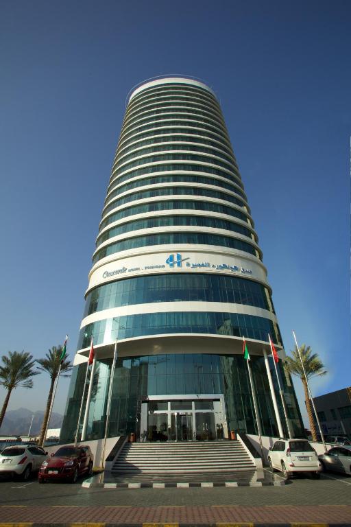 a tall building with cars parked in front of it at Concorde Hotel Fujairah in Fujairah