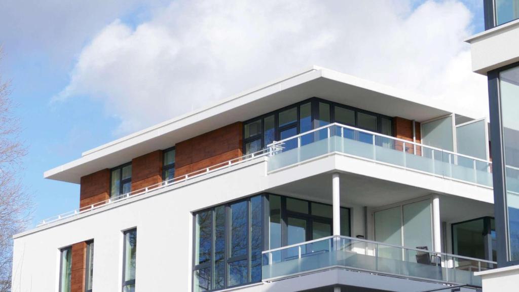 a white building with glass balconies on it at Südkap A-09 in Pelzerhaken