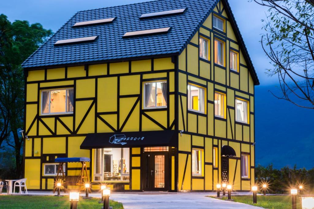 a yellow and black building with a black roof at Elizabeth Bed and Breakfast in Fengli