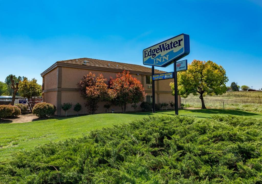 a sign for a hotel in front of a building at Edge Water Inn in Reedley