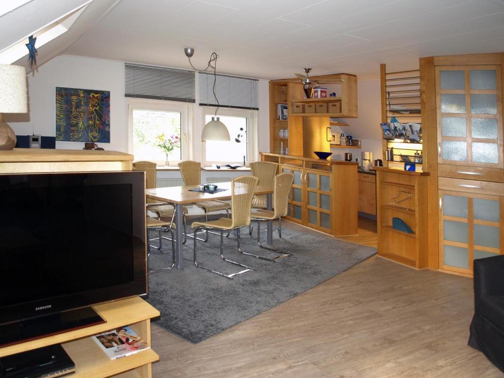 a kitchen and dining room with a table and a television at Ferienwohnung HeeserBerg Xanten in Xanten