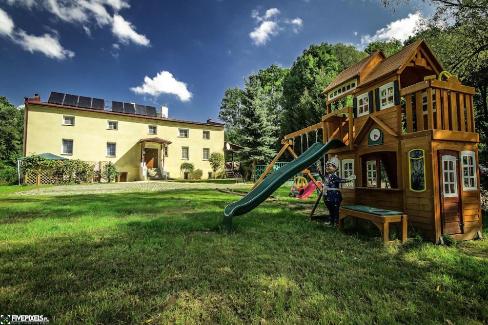 a playground with a slide next to a house at Czarkowice Młyn in Czarkowice