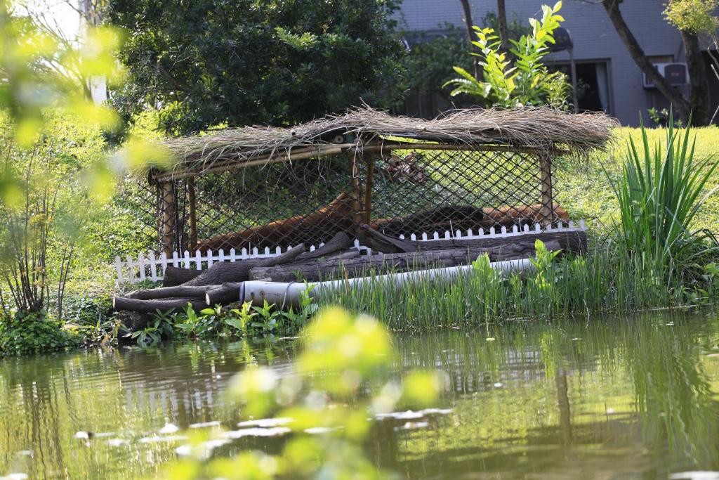 a bird house sitting on top of a pond at Green Forest Villa in Yilan City