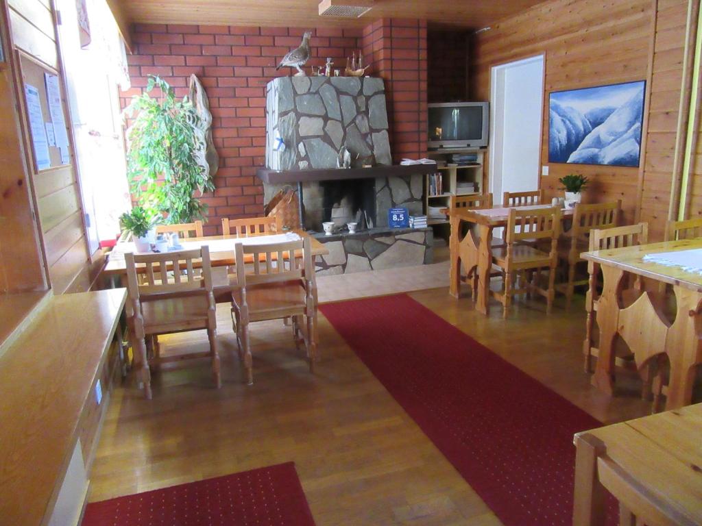 ein Esszimmer mit Tischen, Stühlen und einem Kamin in der Unterkunft Ruska Bed & Breakfast in Taivalkoski
