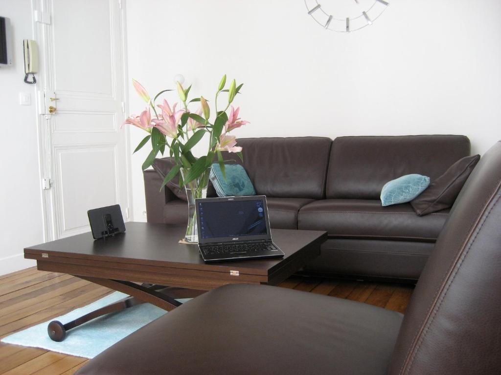 - un salon avec une table basse et un ordinateur portable dans l'établissement Opera Apartment, à Paris