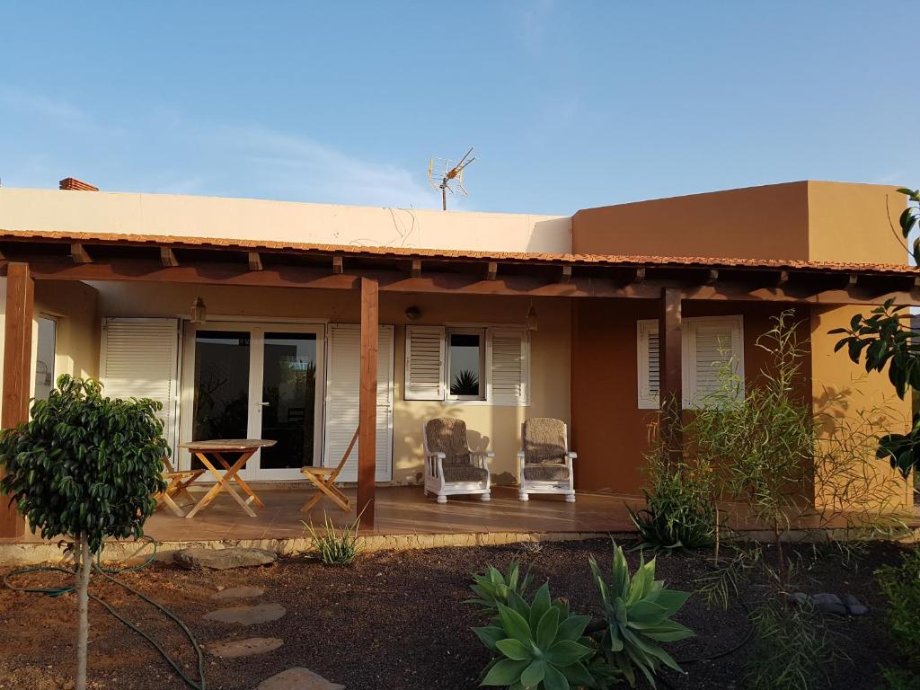 ein Haus mit einer Veranda mit 2 Stühlen und einem Tisch in der Unterkunft Casa de Nico in Antigua