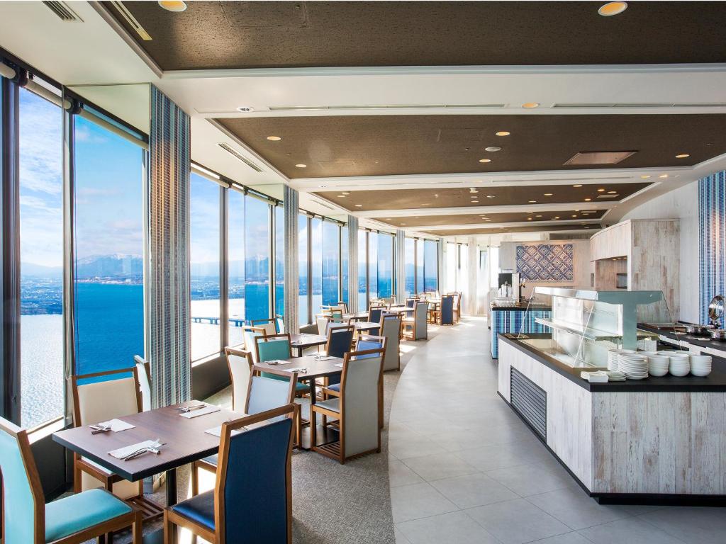 a restaurant with tables and chairs and large windows at Lake Biwa Otsu Prince Hotel in Otsu