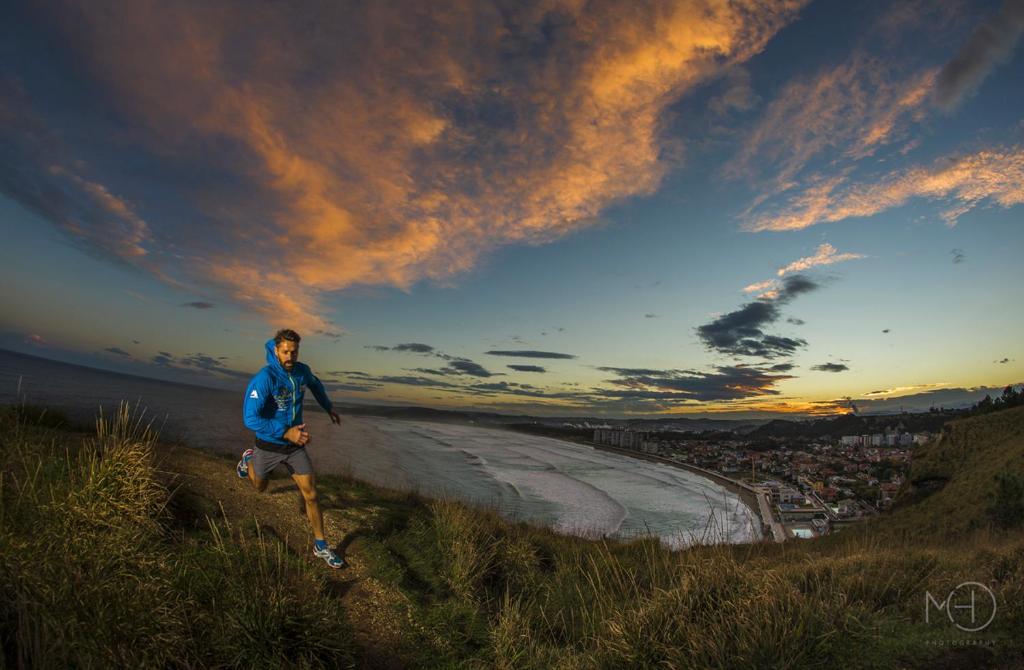 a man running on a hill next to a beach at El Pez Escorpion in Salinas