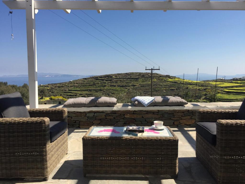 een patio met rieten stoelen en een tafel met uitzicht bij House On the Ancient Footpath in Faros
