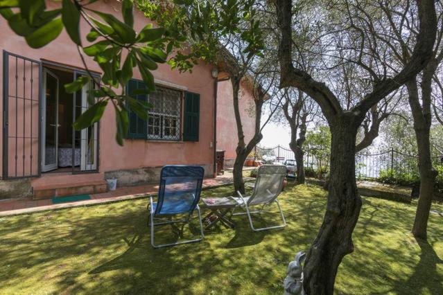 two chairs and a table in front of a house at La Camera Tra Gli Ulivi Dream Finale in Finale Ligure