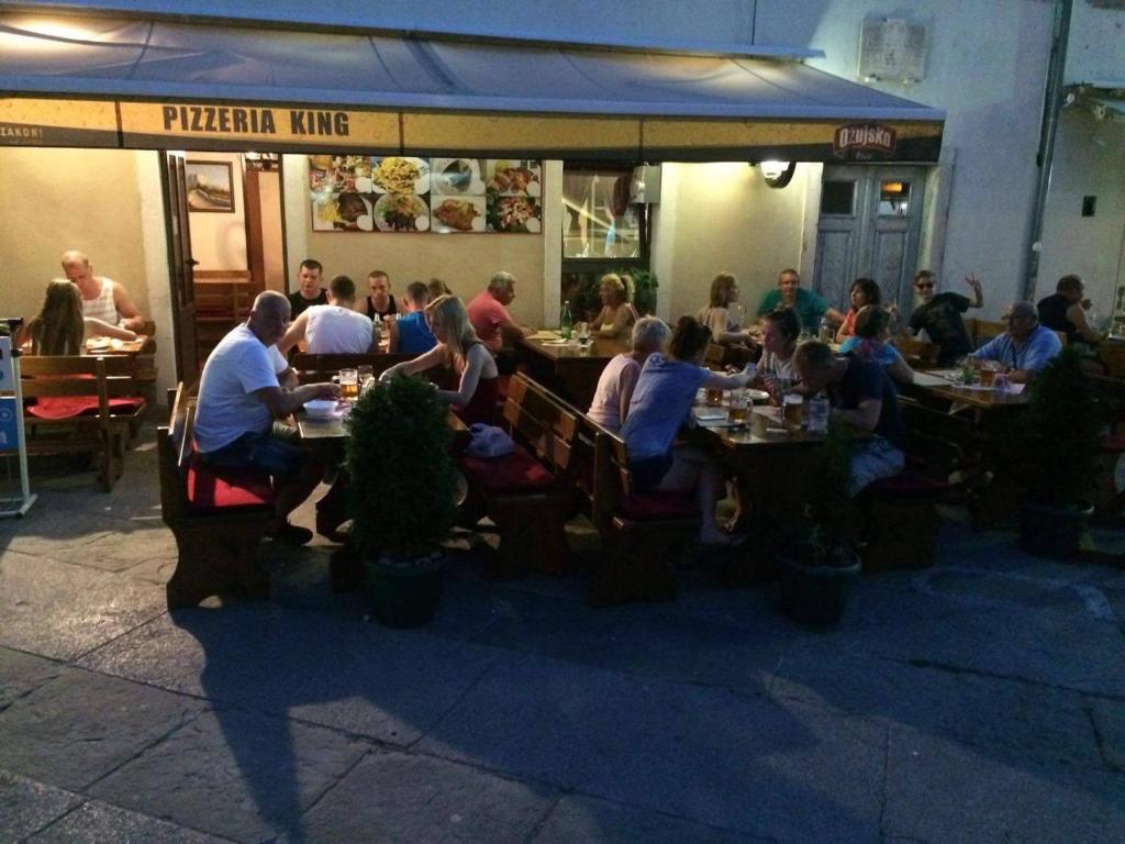a group of people sitting at tables in a restaurant at Apartment Rafael in Senj