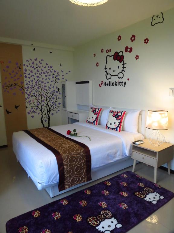 a bedroom with a bed with hello kitty stickers on the wall at Grand Allevia Villa in Wujie