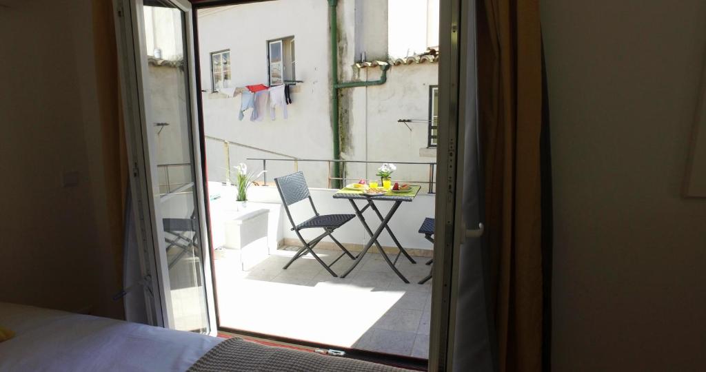 Camera con tavolo e vista su un balcone. di Alfama 44 a Lisbona
