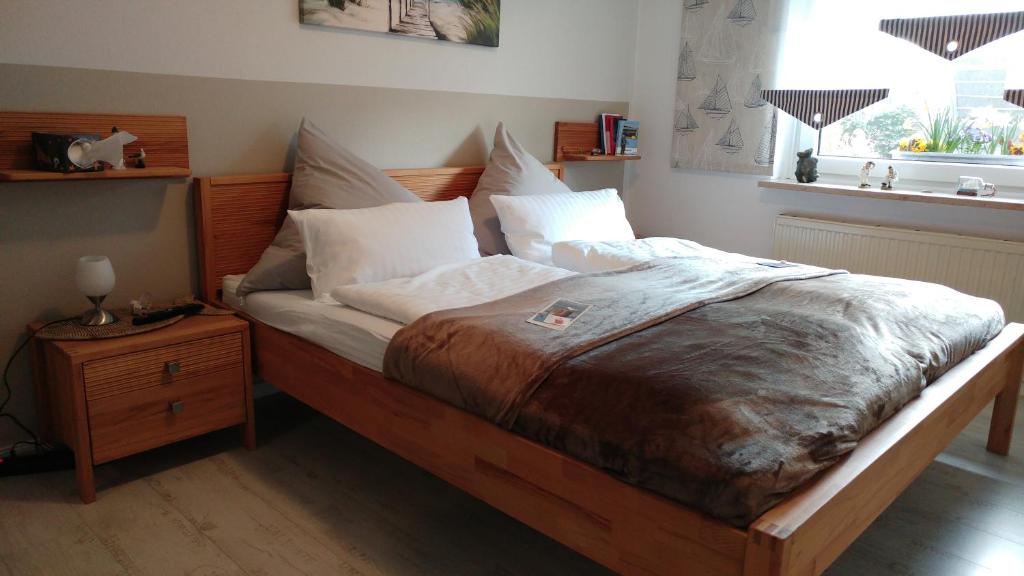 a bedroom with a large bed with white pillows at Eulennest in Tarp