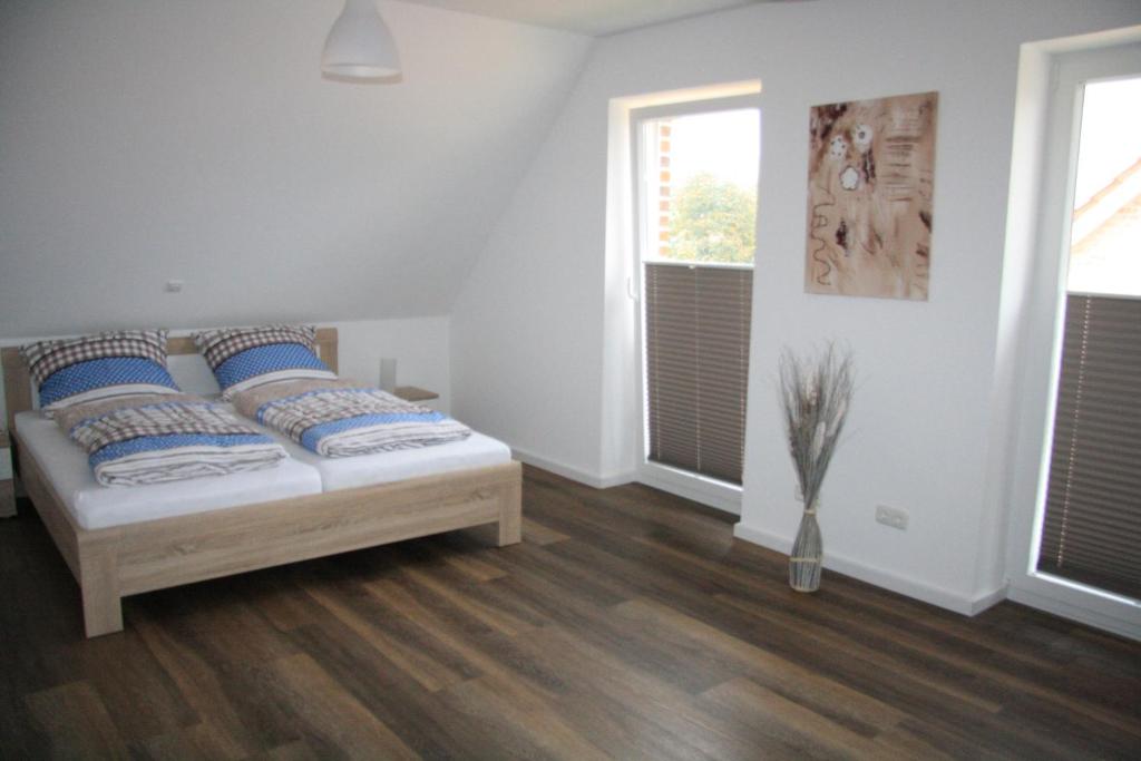 a bedroom with a bed with blue pillows on it at Ferienhaus Sophie in Thülsfeld