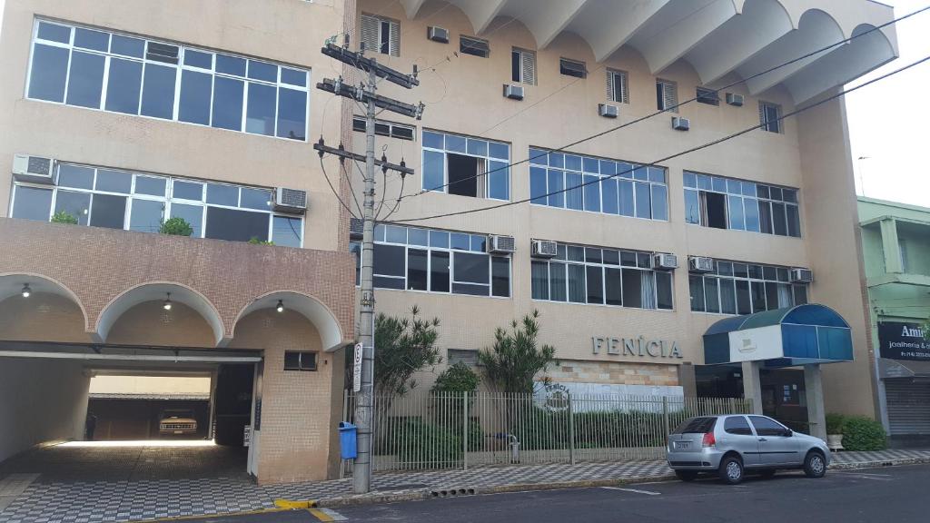 un coche aparcado frente a un edificio en Fenícia Palace Hotel, en Bauru