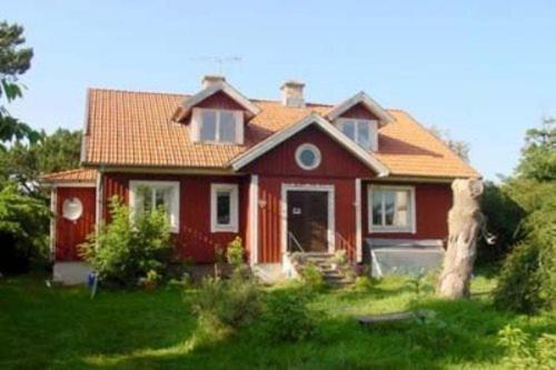 una casa roja con techo rojo en Segerstads Fyr, en Degerhamn