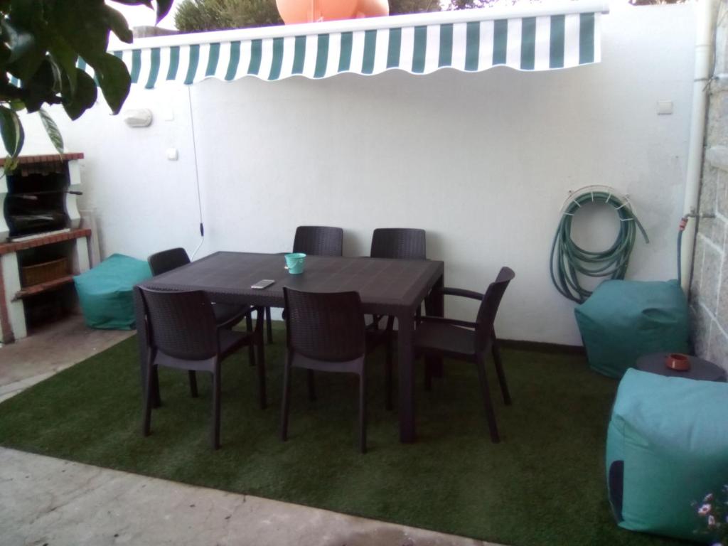 Une table à manger et des chaises sont disponibles sur la terrasse. dans l'établissement Estoril House Family, à Estoril