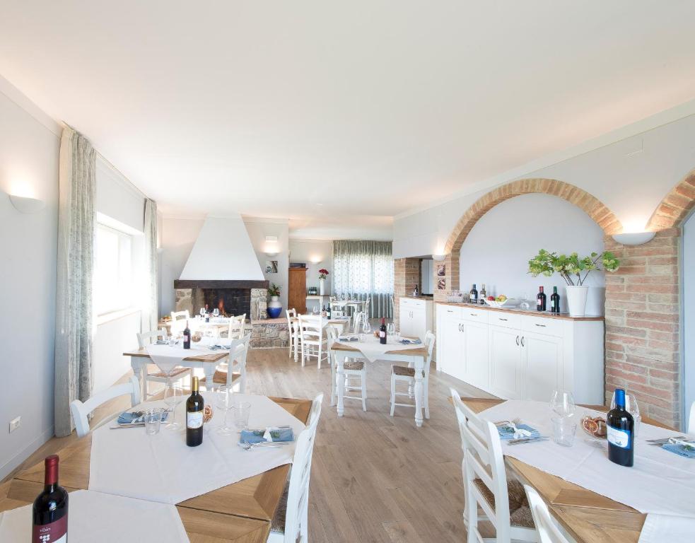 jadalnia z białymi stołami i białymi krzesłami w obiekcie Agriturismo Fattoria di Monticello w mieście San Venanzo