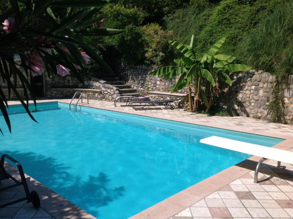 una piscina de agua azul en un complejo en B&B Villa Gardasee With Pool, en Soiano del Lago