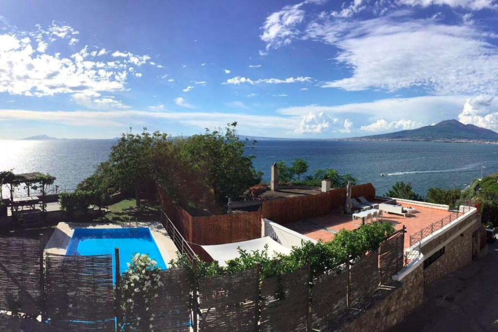a house with a swimming pool next to the ocean at Villa Bikini on Sorrento Coast in Vico Equense