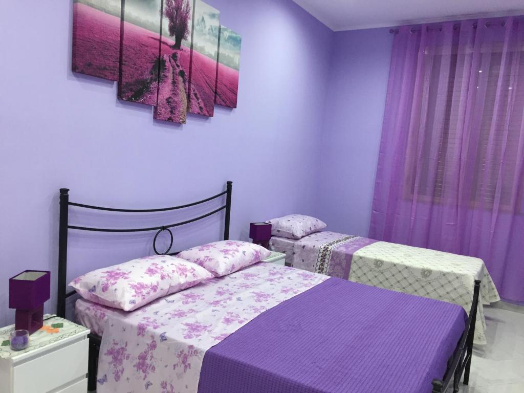 two beds in a bedroom with purple walls at La Casa di Simone in Avola