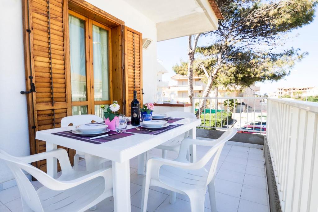 マリーナ・ディ・ラグーザにあるsiciliacasevacanze - Casa Gelsominoの白いテーブルと白い椅子付きのバルコニー