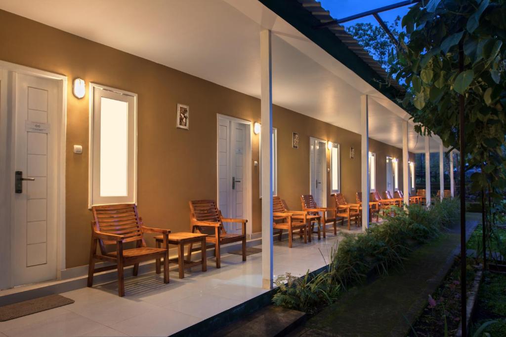 a row of chairs sitting on the side of a building at Rinjani Garden by ecommerceloka in Sembalun Lawang
