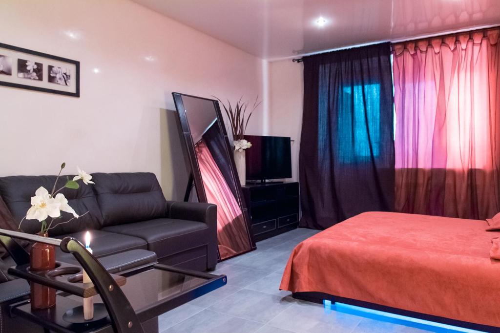 ヴォロネジにあるApartment on 40 let Oktyabrya 14のベッドルーム1室(ベッド1台、ソファ、椅子付)