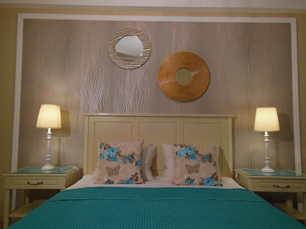 ママイアにあるGabrielle Apartmentのベッドルーム1室(ランプ2つ、鏡付)