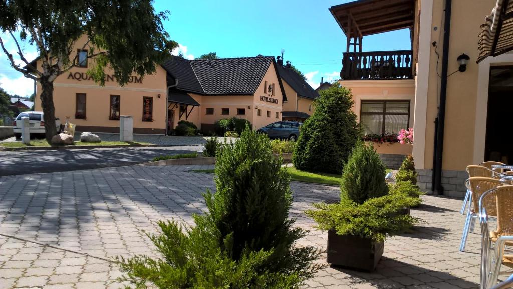 un bâtiment avec une table et des chaises dans une cour dans l'établissement Hotel Slunce, à Rýmařov