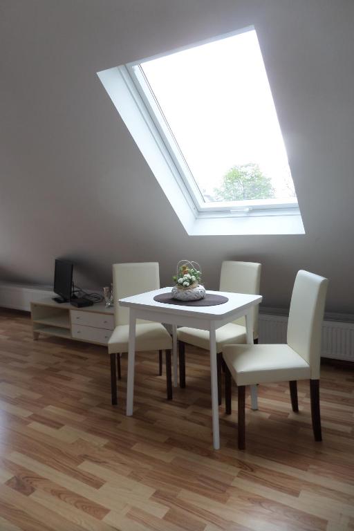 a dining room with a white table and a skylight at Flughafenapartement Sky View in Düsseldorf