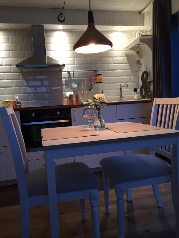 Chez Sven - Studio 'Le Grand' في Lohn-Ammannsegg: مطبخ بطاولة زرقاء وكرسيين