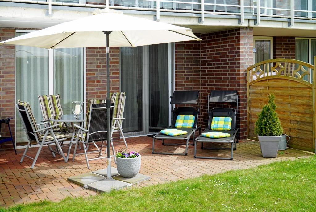 un patio con mesa, sillas y sombrilla en Relaxzone 202 - Hohen Wieschendorf en Hohen Wieschendorf