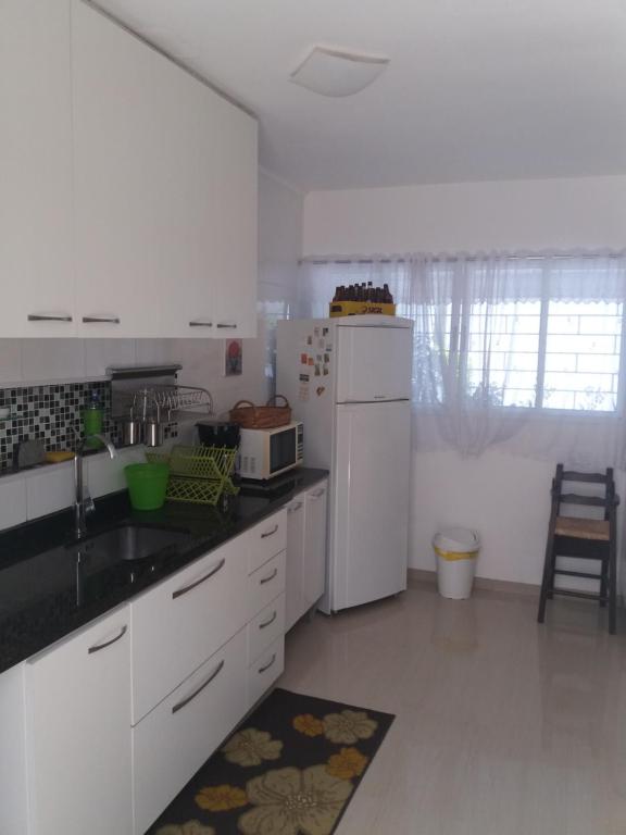 cocina con electrodomésticos blancos y nevera blanca en Casa com garagem em condomínio, en Curitiba