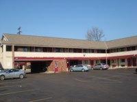 un gran edificio con coches estacionados en un estacionamiento en German Village Inn Motel, en Columbus