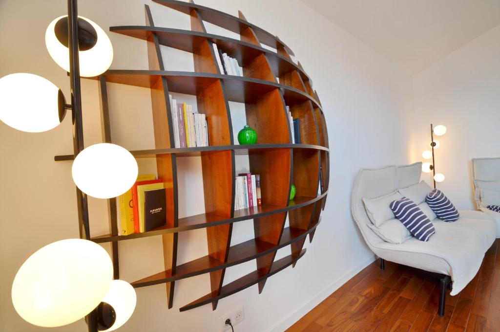 Habitación con estante de libros y silla blanca en Villefranche Sur Mer One Bed, en Villefranche-sur-Mer