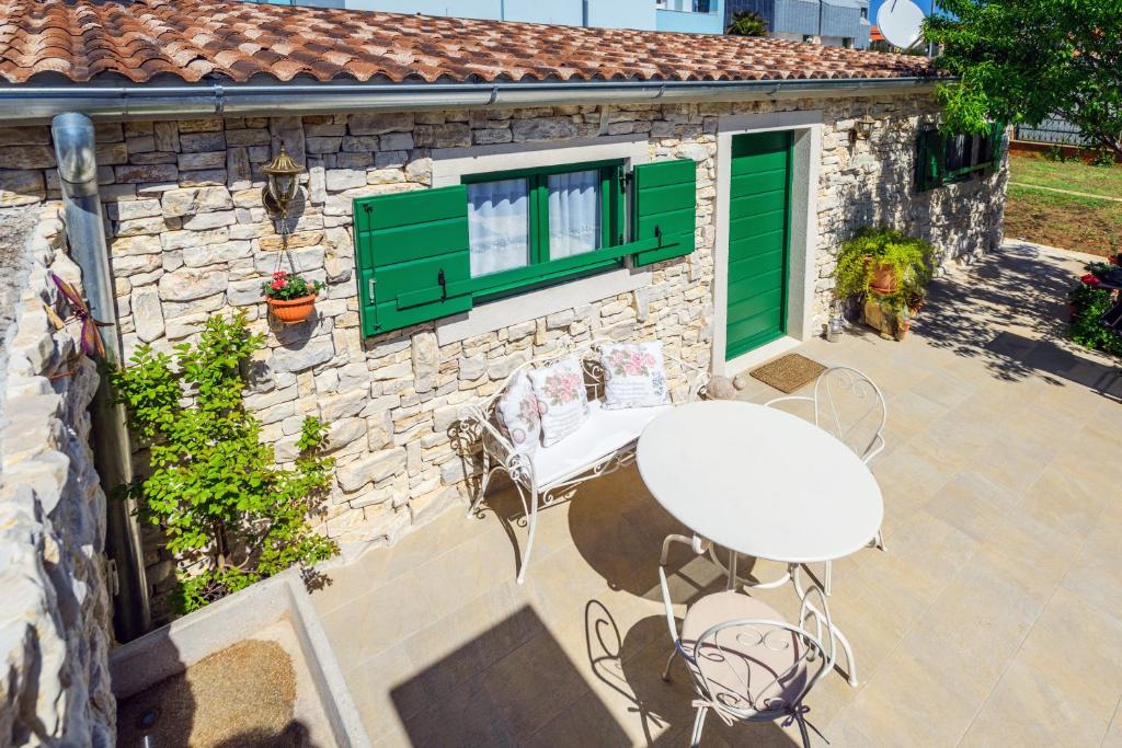 un patio con una mesa y sillas blancas y un edificio en Apartment Old Cottage en Zadar