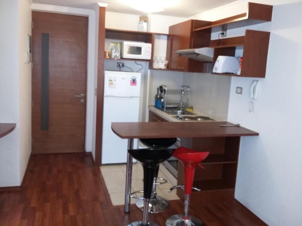 a kitchen with a table and a counter top at Carmen con Argomedo, PARKING por pagar in Santiago