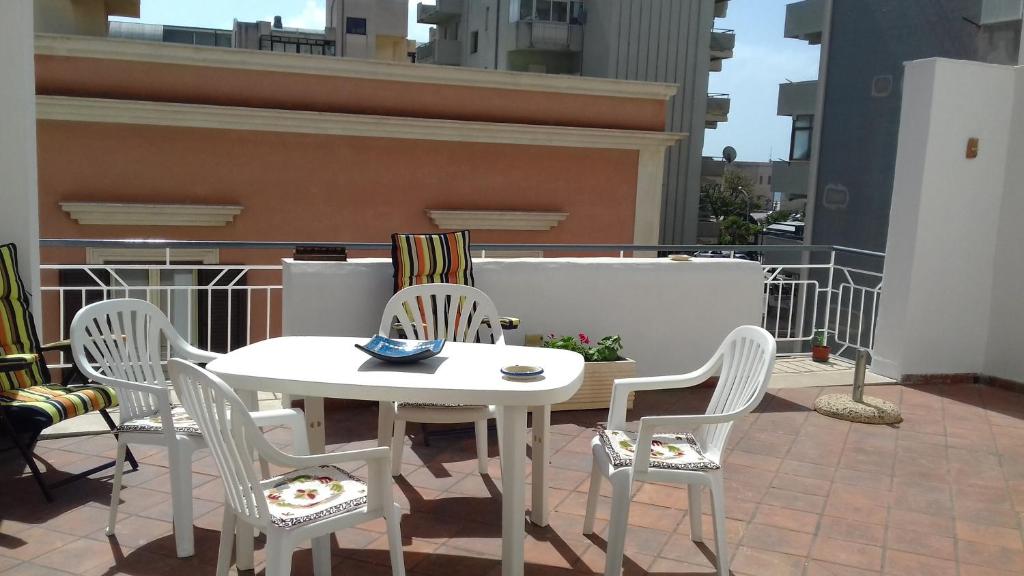 マルサラにあるGuest House Porto Marsalaの白いテーブルと椅子付きのバルコニー