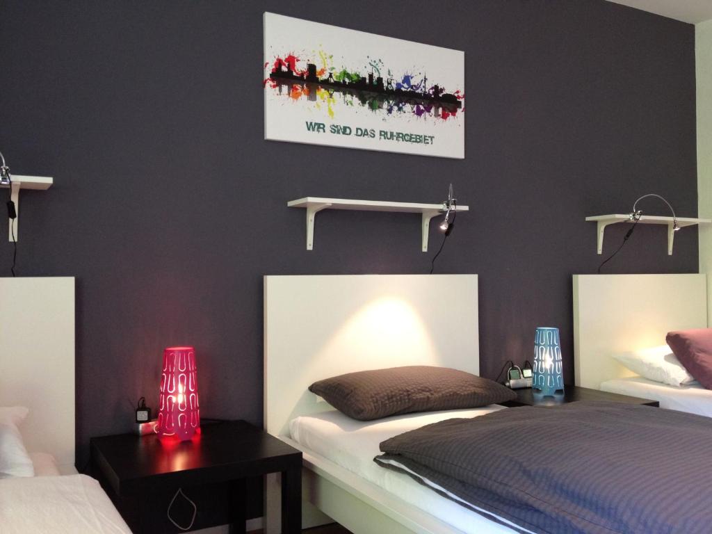 ゲルゼンキルヒェンにあるArena City Apartment Buerのベッドルーム1室(ベッド2台付)が備わります。壁に絵が描かれています。