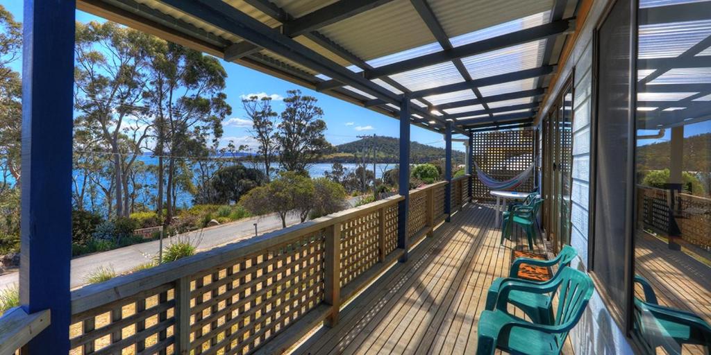 a screened porch with a view of the water at Sommers Bay Beach House in Murdunna