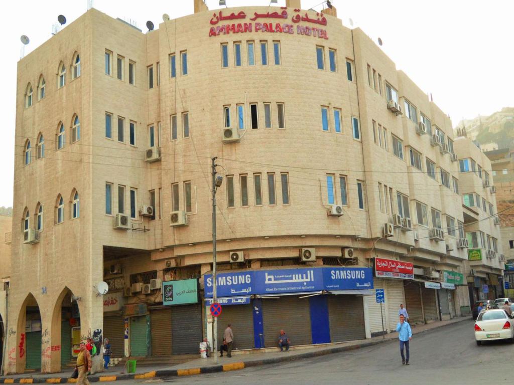 a large building on the corner of a street at Amman Palace Hotel in Amman