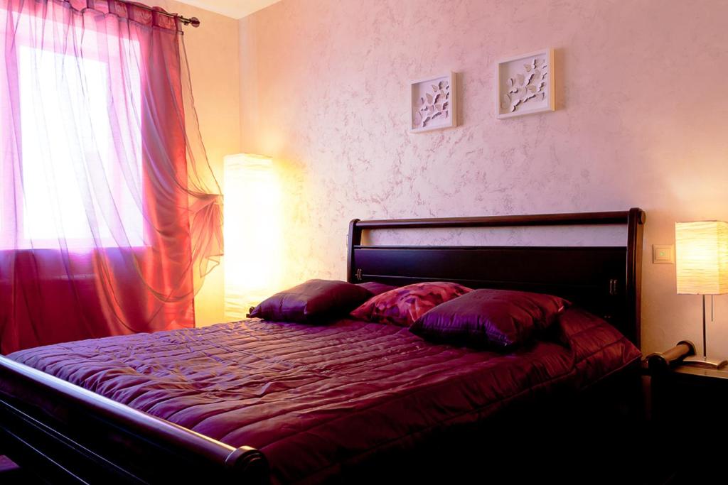ヴォロネジにあるApartment on Kropotkina 5/13のベッドルーム1室(赤いシーツ付きのベッド1台、窓付)