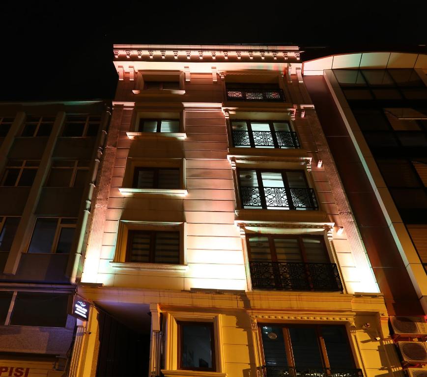 wysoki budynek z oświetleniem w nocy w obiekcie Overland Residence w Stambule