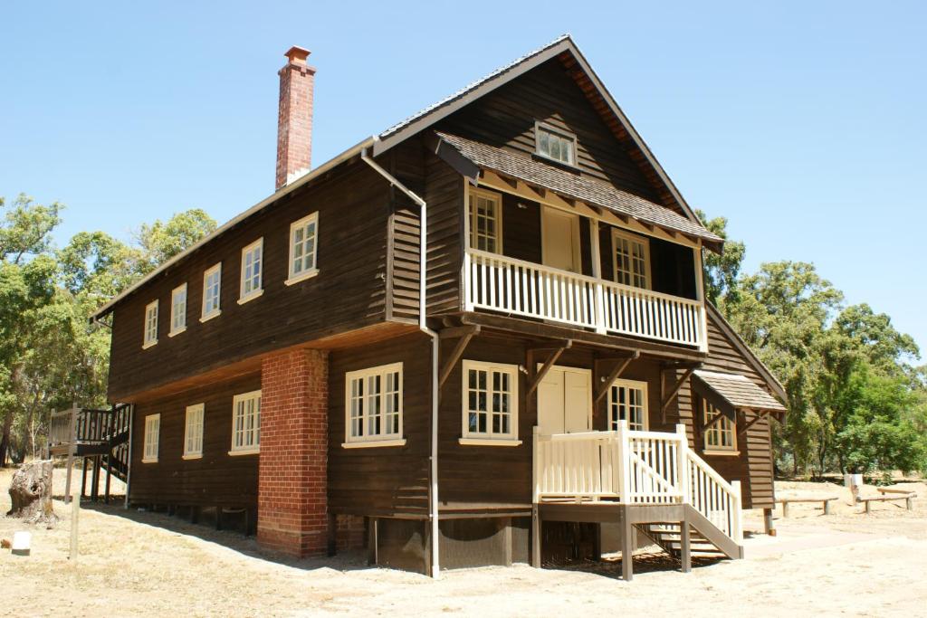 a large wooden house with a porch and a chimney at Fairbridge Village in Pinjarra