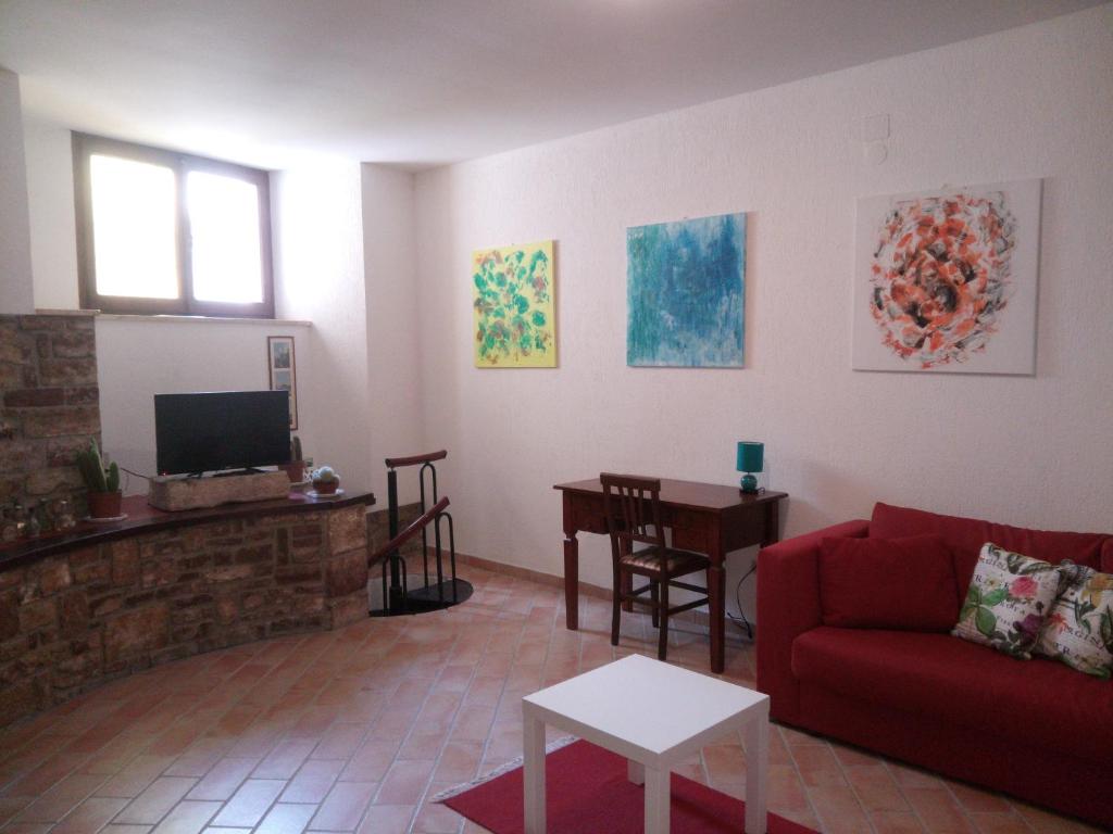 - un salon avec un canapé rouge et une table dans l'établissement Le case di Tiberio, à Assise