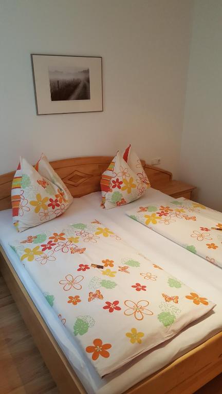 ザンクト・ヴォルフガングにあるAppartement Grabnerのベッド(花の掛け布団付)