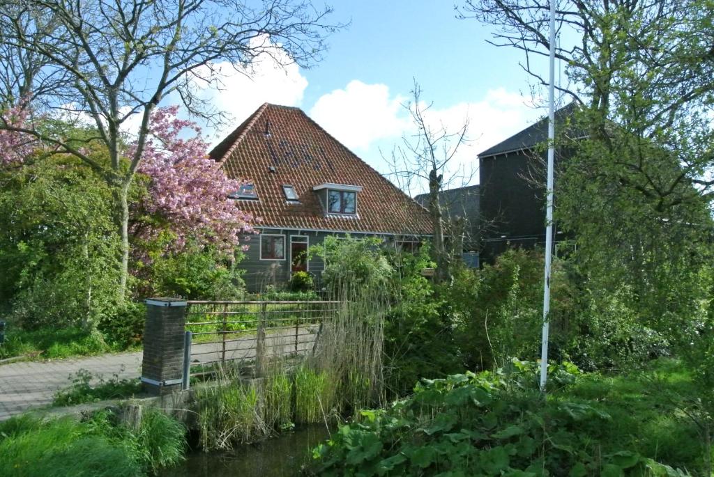 une maison au milieu d'une rivière dans l'établissement Appartement Voorhuis en chalet Klein Waterland, à Amsterdam